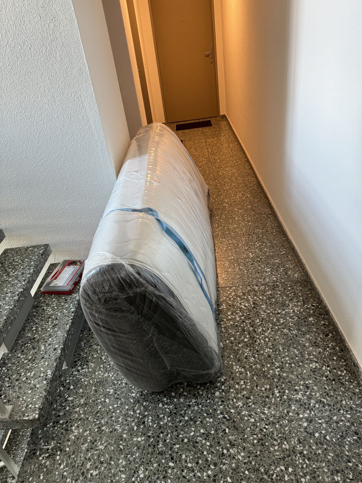 In Folie verpackte Matratze im Treppenhaus